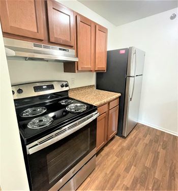 An empty kitchen with a stove and a refrigerator
